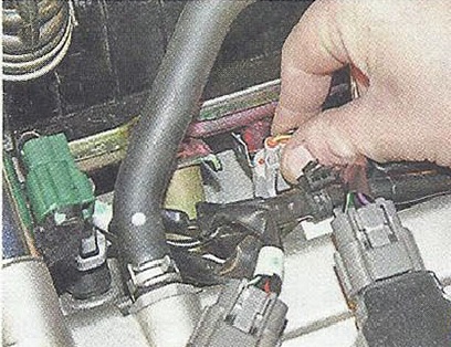 Нажимаем на фиксаторы колодок жгута проводов и отсоединяем колодки от выводов форсунок Nissan Primera