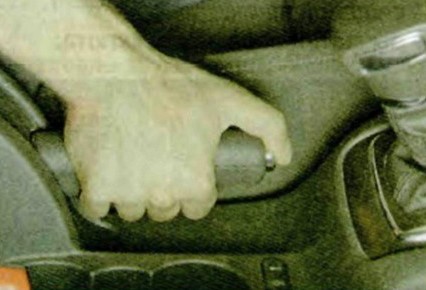 Чтобы растормозить автомобиль, потяните рычаг немного вверх, нажмите на кнопку в торце рукоятки рычага и опустите рычаг до упора вниз Шкода Октавия