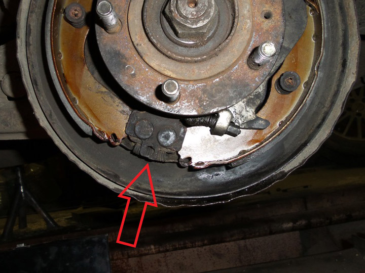 Расположение нижней пружины соединяющей тормозные колодки барабанного механизма Mitsubishi Outlander I 2003 - 2008