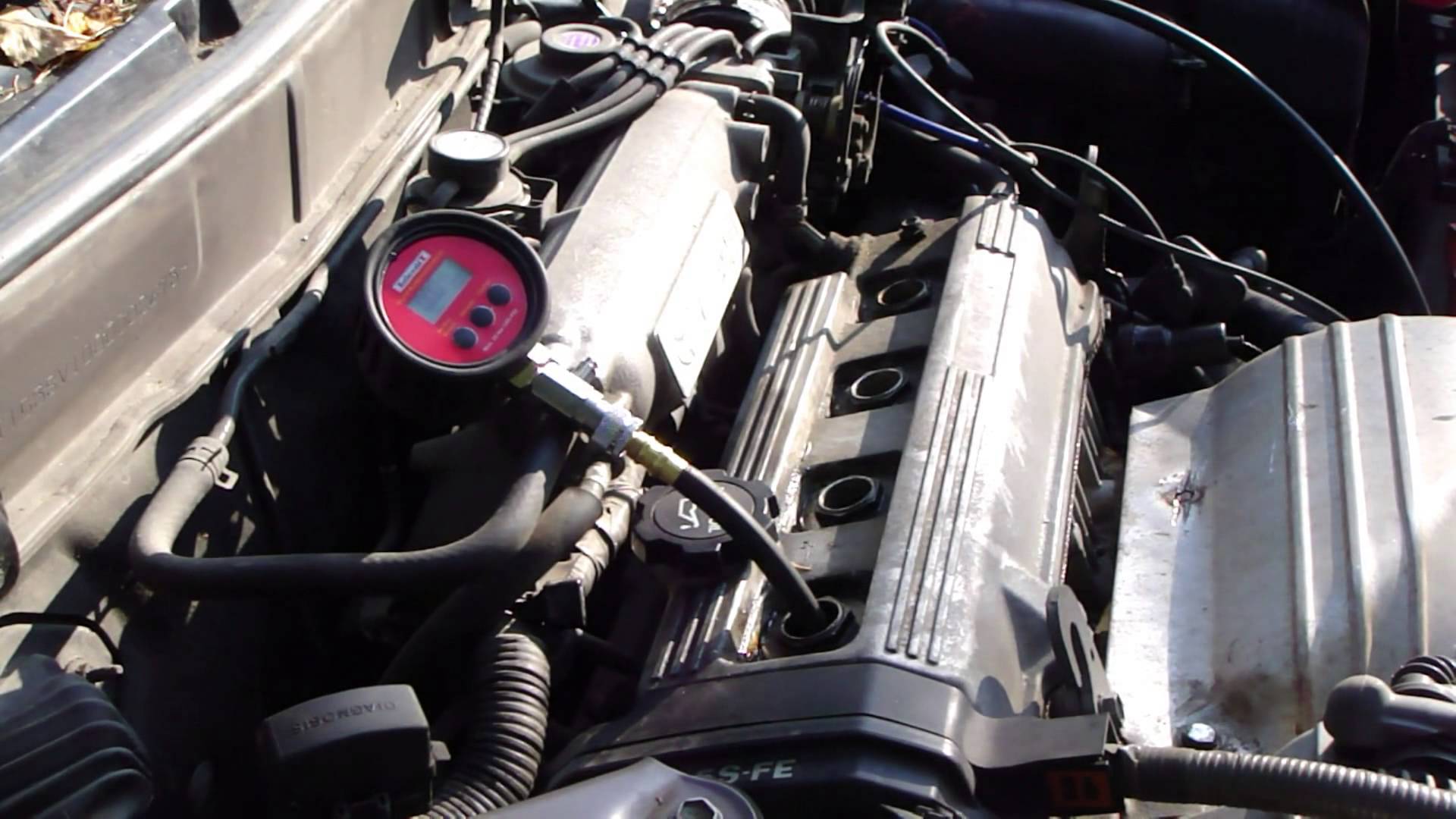 Ввернутый компрессометр в отверстие свечи зажигания двигателя Toyota RAV4