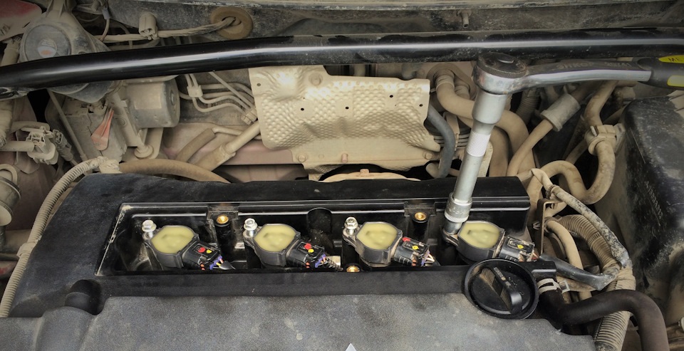Отворачивание болта крепления катушки зажигания двигателя 4B12 Mitsubishi Outlander XL