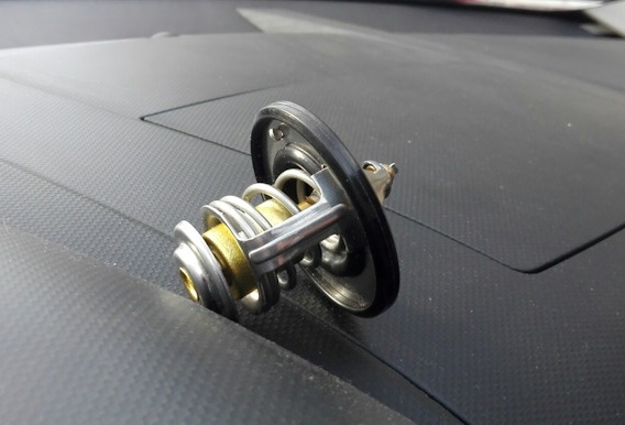 Снятый термостат в сборе с уплотнительным кольцом двигателя Mitsubishi Outlander XL