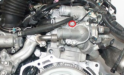 Размещение болта крепления провода массы к корпусу термостата двигателя 4B12 Mitsubishi Outlander XL