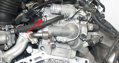 Размещение хомута крепления шланга системы охлаждения к патрубку корпуса термостата двигателя 4B12 Mitsubishi Outlander XL