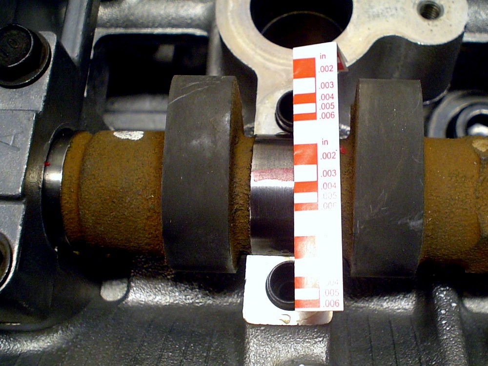 Измерение ширины раздавленного пластикового калибра на опорной шейке подшипника распределительного вала двигателя 4B12 Peugeot 4007