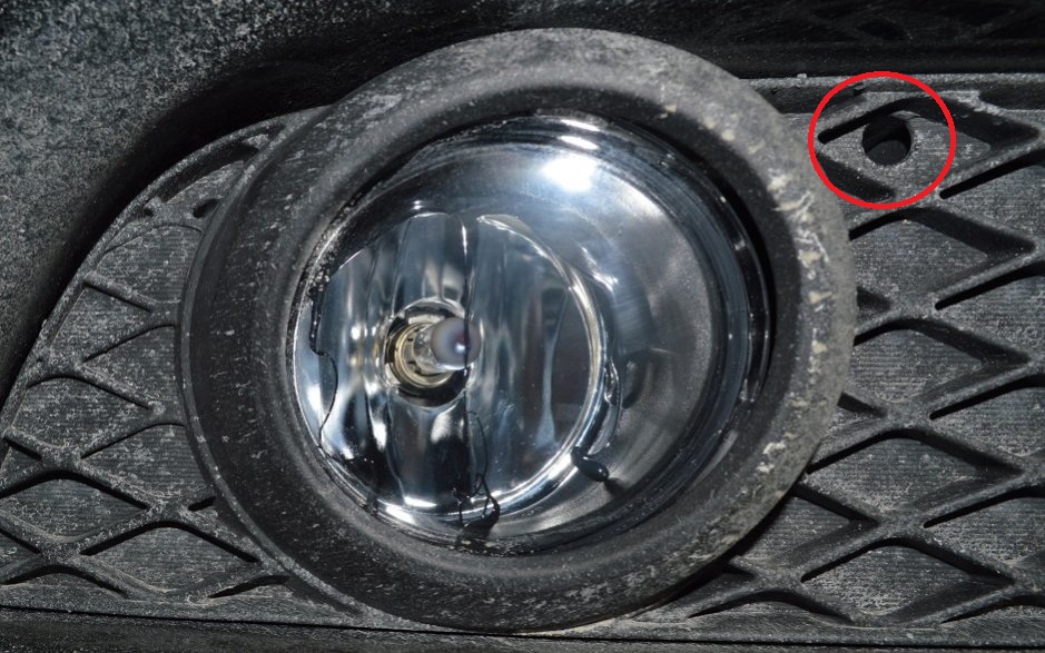 Расположение отверстия регулировки противотуманной фары на автомобиле Mitsubishi Lancer 10 