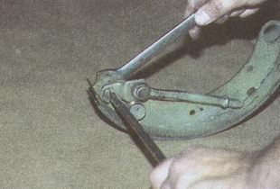 Ключом «на 17» отворачиваем гайку болта-оси разжимного стержня, удерживая болт-ось шлицевой отверткой ГАЗ 31105 Волга