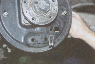Выводим наконечник троса ручного тормоза из отверстия тормозного щита ГАЗ 31105 Волга