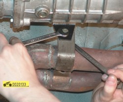 Отверните гайку болта крепления приемной трубы к кронштейну на коробке передач ГАЗ 31105 Волга