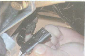 Извлечение колодки жгута проводов датчика концентрации кислорода из держателя на коробке передач Renault Logan
