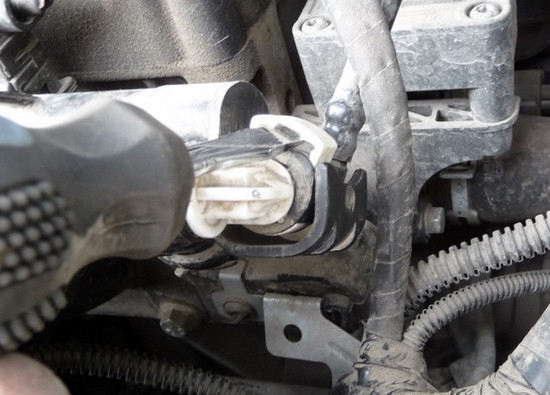 Сдвигание наружу пластмассового фиксатора наконечника трубки подвода топлива Ford Focus 2