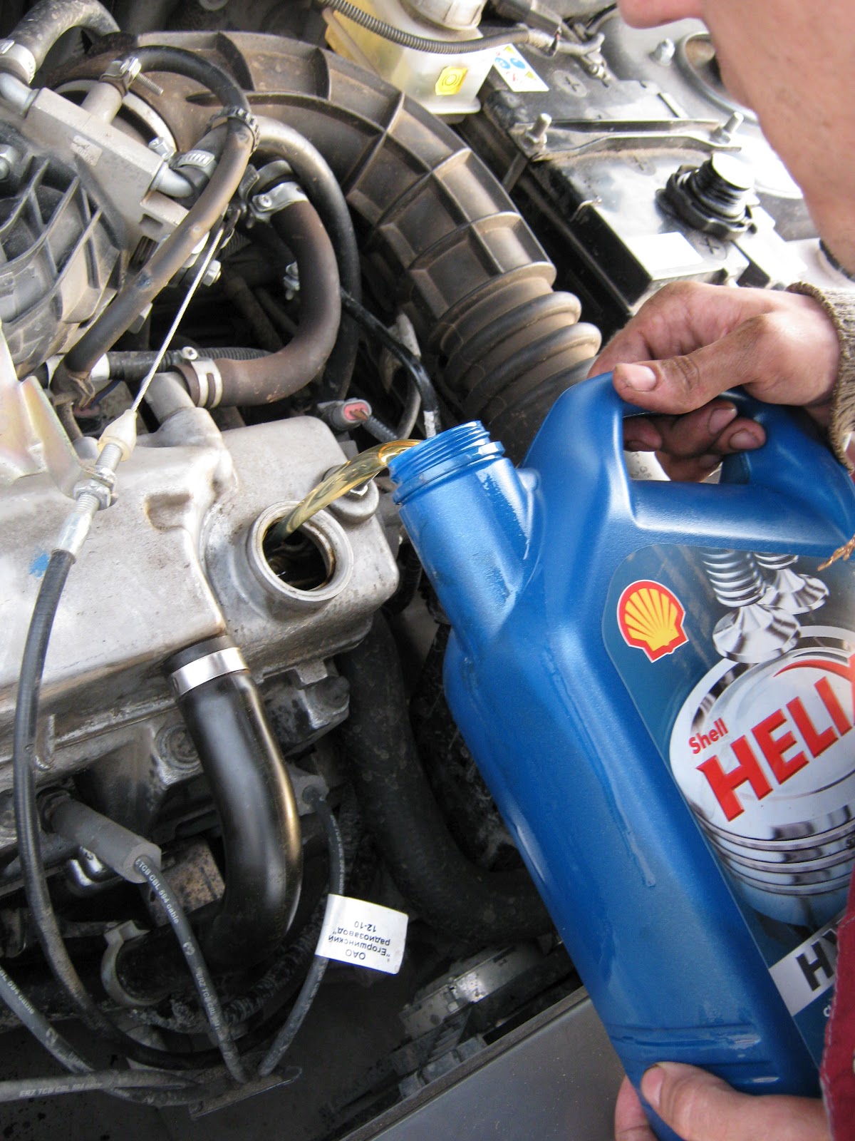 Заливка моторного масла через маслозаливную горловину двигателя Lada Kalina