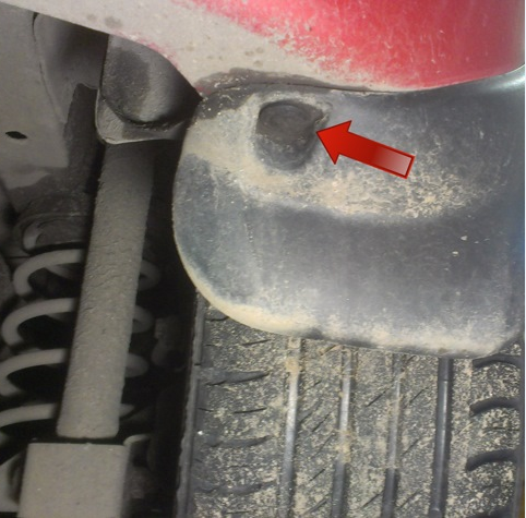 Крестообразной отвёрткой выворачиваем фиксатор пистона нижнего крепления брызговика к заднему бамперу на автомобиле Hyundai Solaris