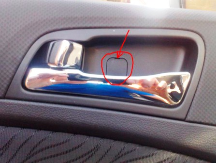 Поддеваем отвёрткой заглушку в декоративной накладке внутренней ручки двери на автомобиле Hyundai Solaris