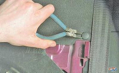 Снимите фиксатор крышки отделяющей салон от багажника на автомобиле Hyundai Solaris