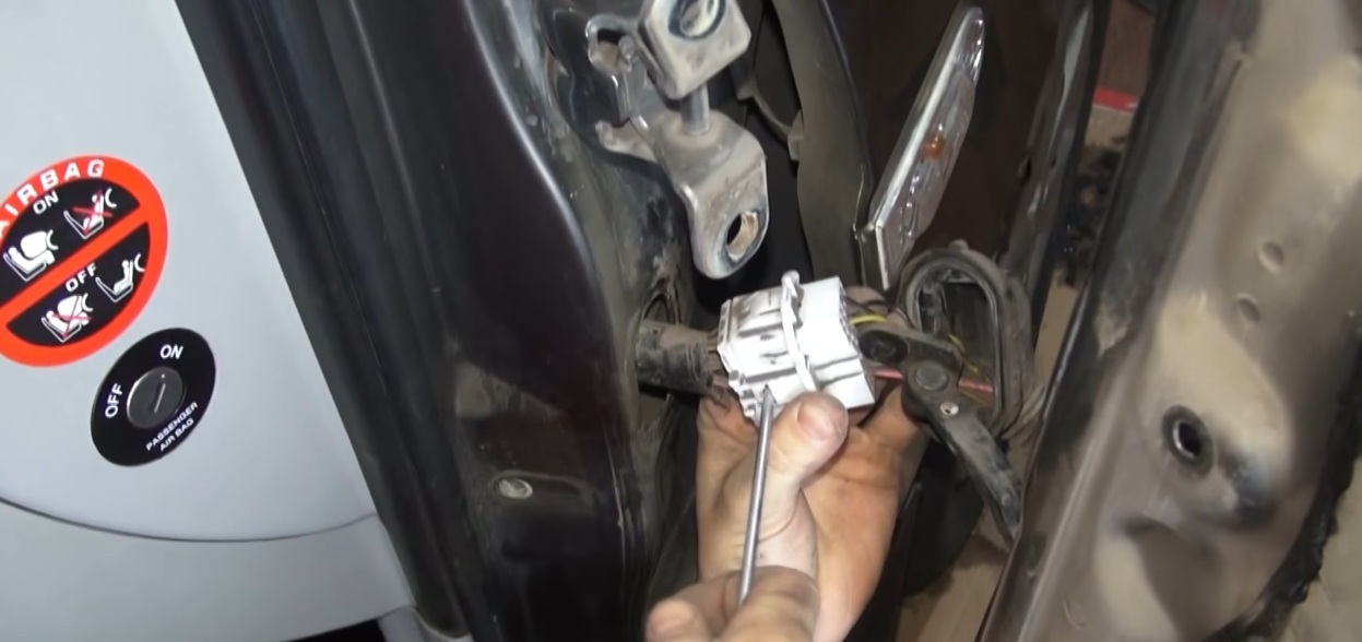 Отсоединить фиксатор колодки жгута проводов передней двери на автомобиле Hyundai Accent MC