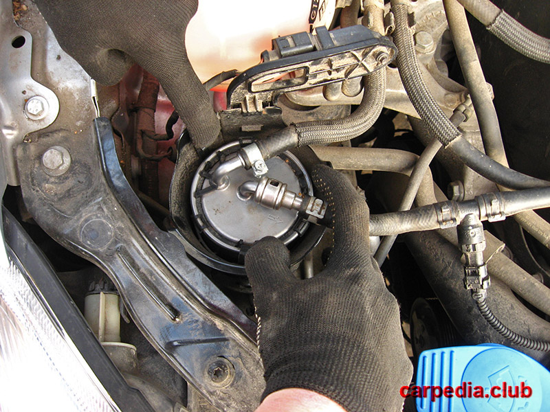 Отжать фиксаторы защитного кожуха топливного фильтра дизеля на автомобиле Skoda Fabia MK2 5J 2007-2014