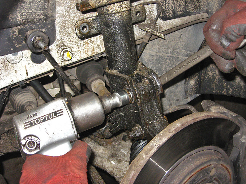 Открутить верхнее крепление амортизатора к поворотному кулаку на автомобиле Nissna Primastar 2001-2014