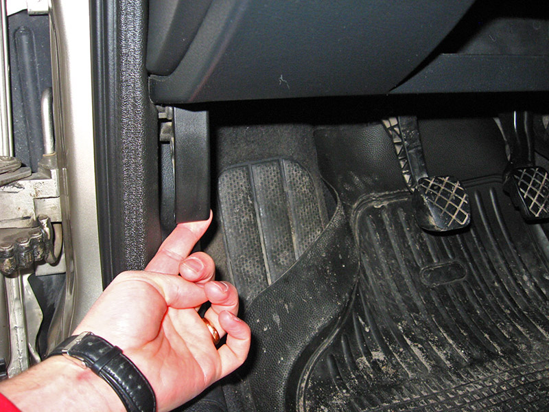 Потягивание на себя рукоятки привода замка капота в салоне автомобиля Skoda Octavia I Tour 