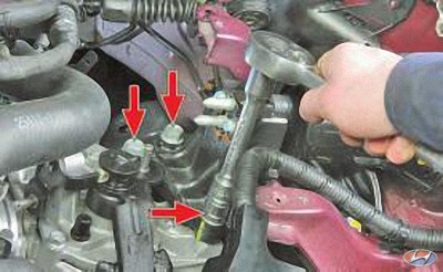 Выверните три болта крепления коробки передач к кронштейну опоры подвески силового агрегата на автомобиле Hyundai Solaris