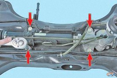 Выверните четыре болта крепления рулевого механизма к поперечине на автомобиле Hyundai Solaris