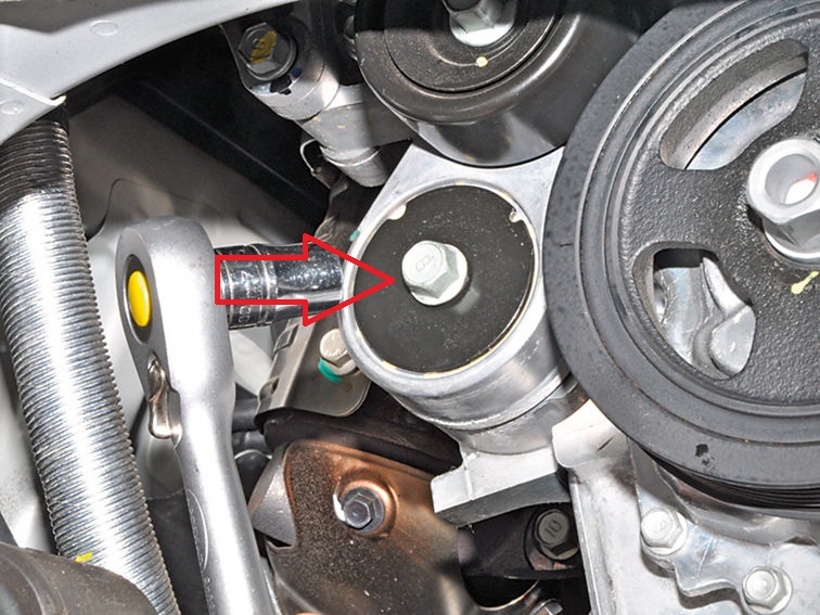 Выверните болт крепления натяжителя ремня привода вспомогательных агрегатов на автомобиле Hyundai Solaris