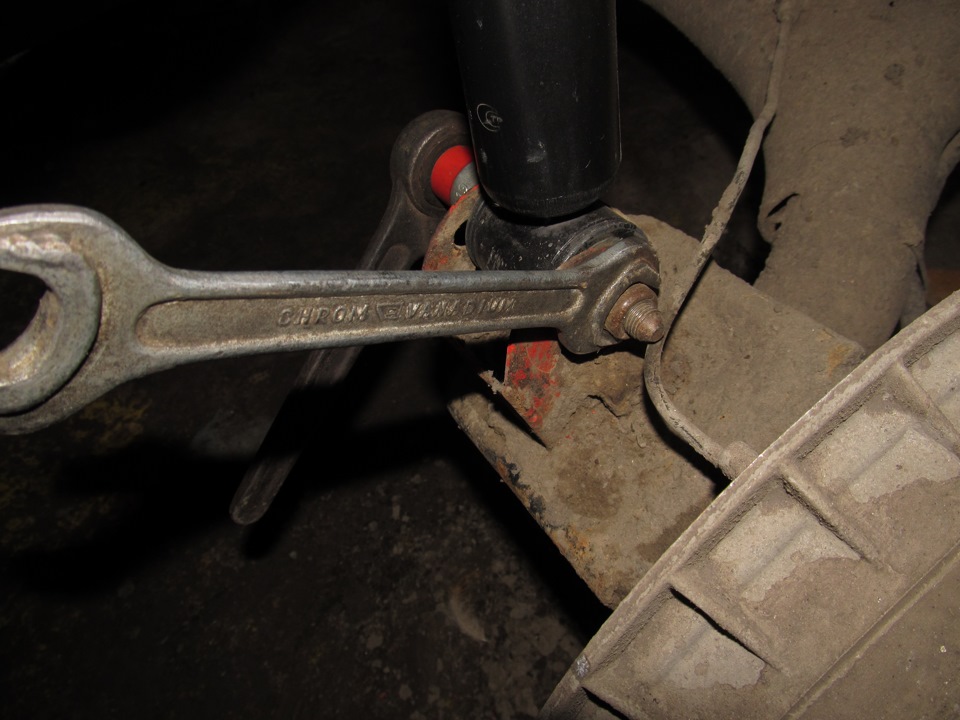 Откручивание нижнего крепления амортизатора от балки задней подвески Лада Гранта (ВАЗ 2190)