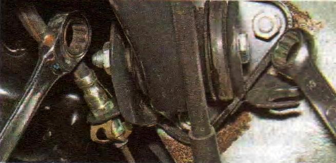 Откручивание гайки крепления рычага балки задней подвески к кронштейну кузова Лада Гранта (ВАЗ 2190)