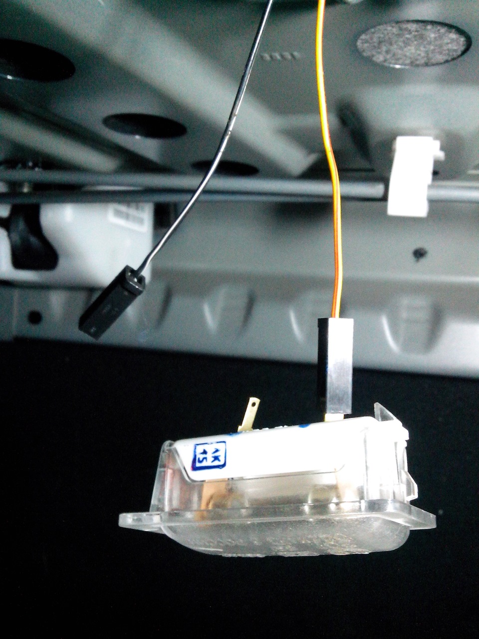 Отсоединение наконечников проводов от выводов плафона освещения багажника Лада Гранта (ВАЗ 2190)