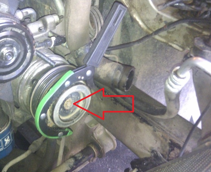 Вывернуть болт крепления прижимной пластины компрессора кондиционера на автомобиле Hyundai Solaris