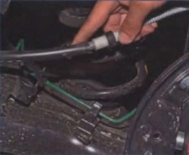 Снятие троса ручного привода тормоза из держателя на рычаге задней подвески Lada Largus