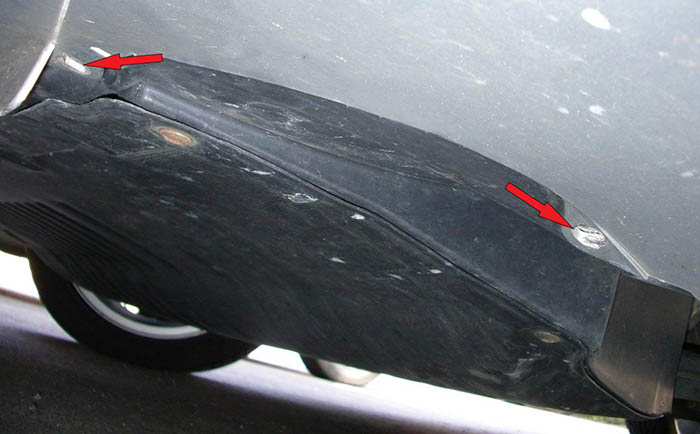 Выкрутка шурупов с каждой стороны в нижней части буфера возле колесных арок автомобиля Skoda Fabia I