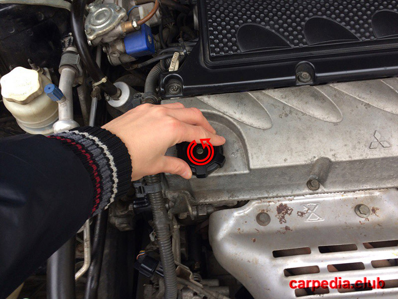Открутить пробку маслозаливной горловины двигателя на автомобиле Mitsubishi Galant IX