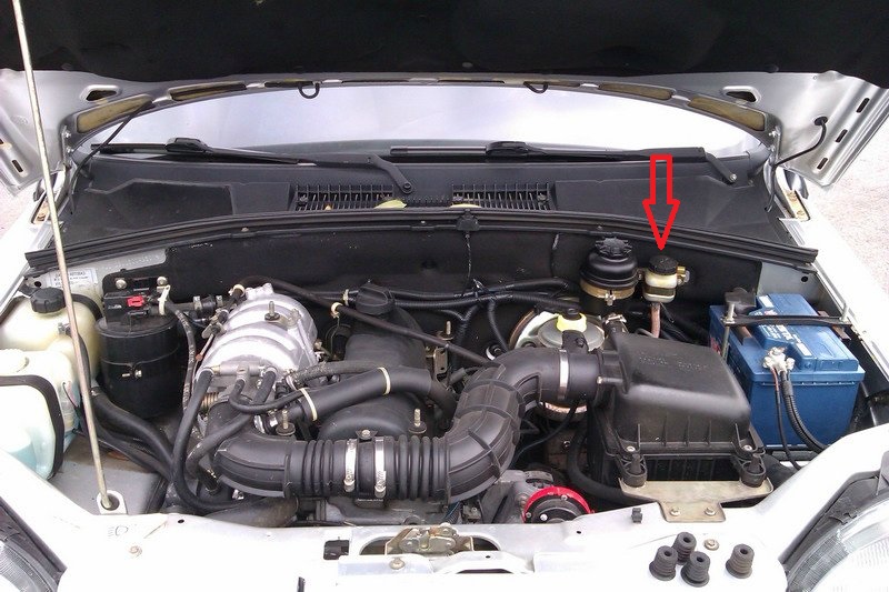 Бачок гидропривода сцепления расположен в моторном отсеке слева и прикреплен к щитку передка Chevrolet Niva