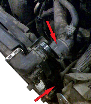 Отсоединение отводящего и подводящего шлангов от патрубка радиатора автомобиля Skoda Fabia I