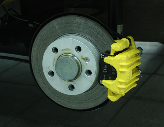 Покрытый краской (покрашен кистью) тормозной суппорт без снятия с тормозного диска автомобиля Skoda Fabia