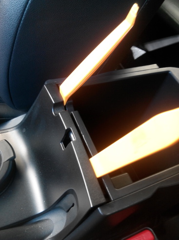 Отжать фиксаторы крепления центральной консоли пола на автомобиле Hyundai ix35