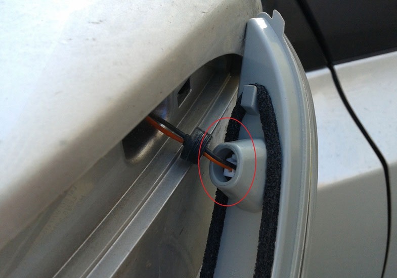 Отсоединить колодку проводов повторителя поворота бокового зеркала на автомобиле Hyundai ix35