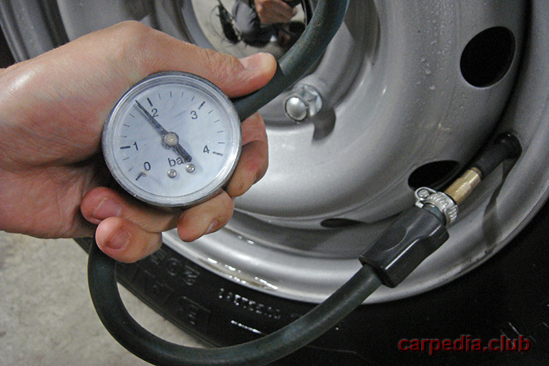 Проверка манометром давления в шине колеса Chevrolet Niva