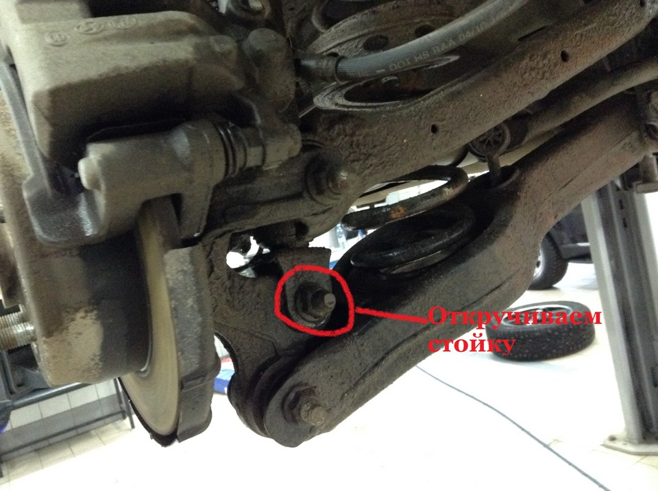 Открутить нижнее крепления заднего амортизатора 2WD на автомобиле Hyundai ix35