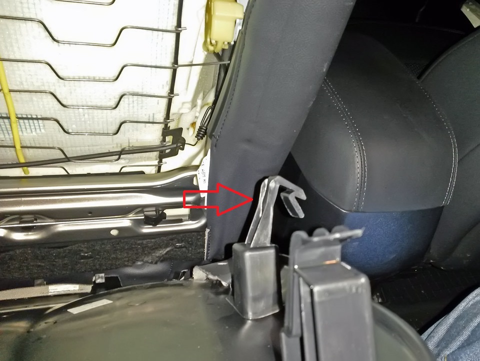 Отогнуть боковые фиксаторы крышки водительского сиденья на автомобиле Hyundai ix35