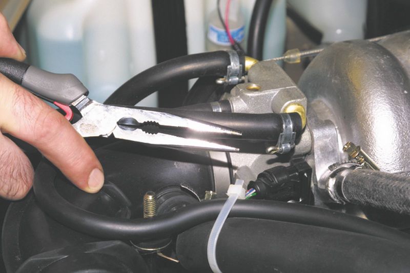Ослабление хомута крепления шланга подвода охлаждающей жидкости к дроссельному узлу Chevrolet Niva