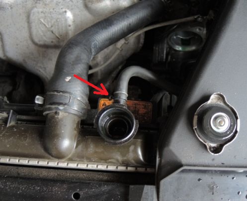 Размещение хомута крепления пароотводящего шланга системы охлаждения двигателя к заливной горловине радиатора Mitsubishi Outlander I