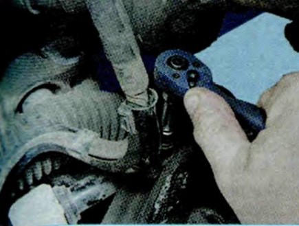 Откручивание болта крепления держателя жгута проводов рулевого механизма Шкода Октавия
