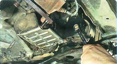 Отворачивание болта крепления передней опоры двигателя к кронштейну Mitsubishi Outlander XL