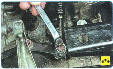 Выкручивание гайки для выведение троса привода из держателей Mitsubishi Outlander XL II