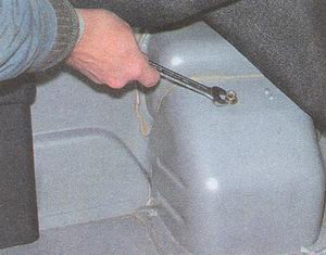 Отогнув обивку в багажнике ключом «на 12» отворачиваем болт крепления наливной горловины бензобака ГАЗ 31105 Волга