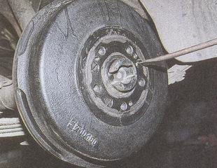 Плоской отверткой отворачиваем три винта крепления тормозного барабана ГАЗ 31105 Волга