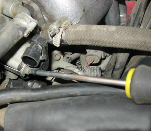Отворачивание верхнего винта крепления датчика положения дроссельной заслонки Chevrolet Niva