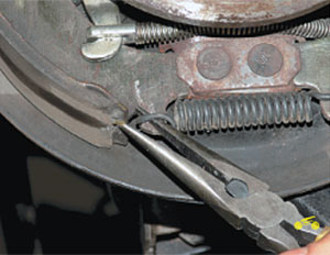 Снятие нижней стяжной пружины задних колодок Chevrolet Niva